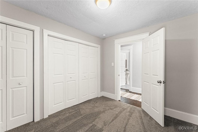 unfurnished bedroom with baseboards, a closet, carpet, and a textured ceiling
