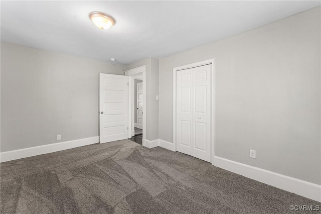 unfurnished bedroom featuring carpet floors, baseboards, and a closet