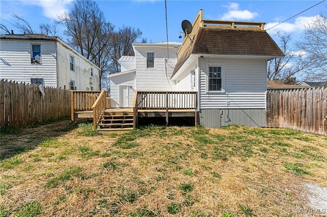 rear view of property with a fenced backyard, a yard, and a deck