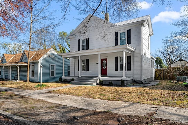 view of front of home featuring a porch, fence, and a chimney