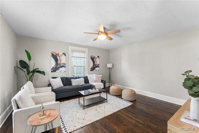 living area with baseboards, wood finished floors, ceiling fan, and a textured ceiling