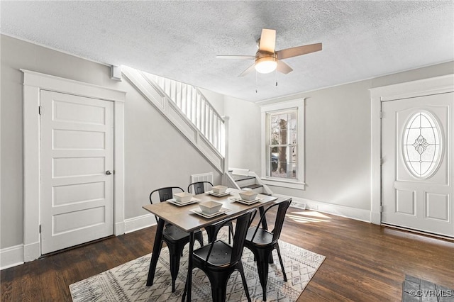 dining space with baseboards, ceiling fan, wood finished floors, and stairway