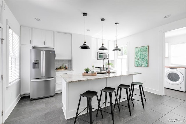 2205 Fairmount Ave, Richmond, VA 23223 - kitchen featuring washer / clothes dryer, a sink, a wealth of natural light, and stainless steel appliances