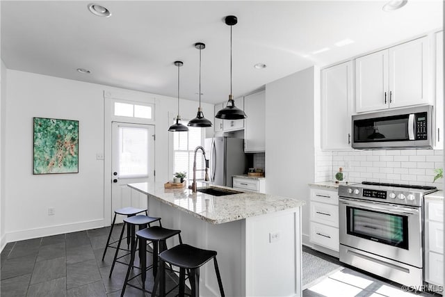 2205 Fairmount Ave, Richmond, VA 23223 - kitchen with stainless steel appliances, a center island with sink, a sink, and backsplash