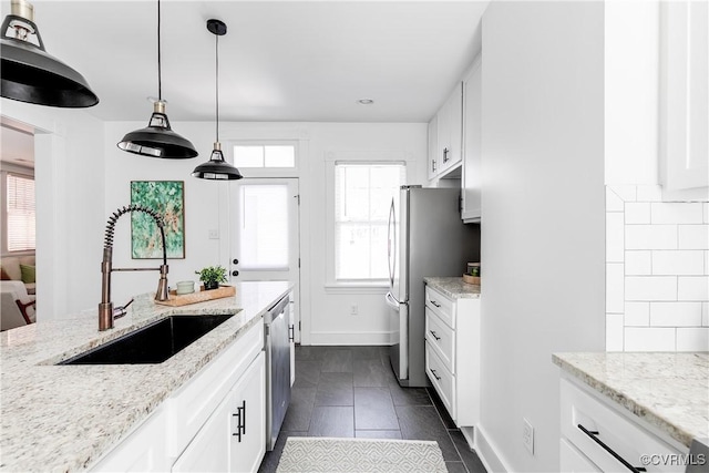 2205 Fairmount Ave, Richmond, VA 23223 - kitchen featuring appliances with stainless steel finishes, a sink, white cabinetry, and light stone countertops
