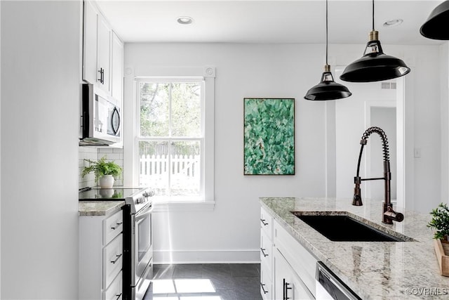 2205 Fairmount Ave, Richmond, VA 23223 - kitchen featuring appliances with stainless steel finishes, a sink, white cabinetry, and light stone counters