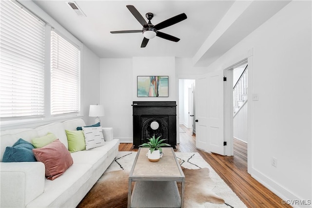 2205 Fairmount Ave, Richmond, VA 23223 - living room featuring ceiling fan, a fireplace with flush hearth, visible vents, wood finished floors, and baseboards