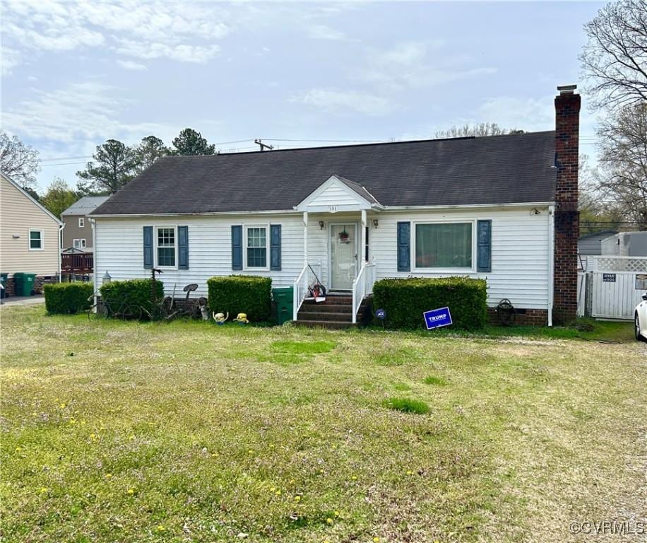 ranch-style home with a front lawn, a chimney, and roof with shingles