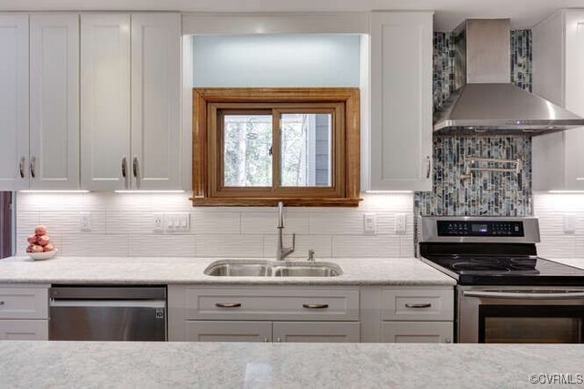 6920 Apamatica Ln, Chesterfield, VA 23838 - kitchen with stainless steel appliances, wall chimney range hood, backsplash, white cabinetry, and light stone counters