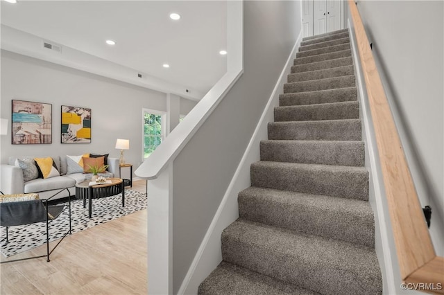 stairs featuring baseboards, visible vents, wood finished floors, and recessed lighting