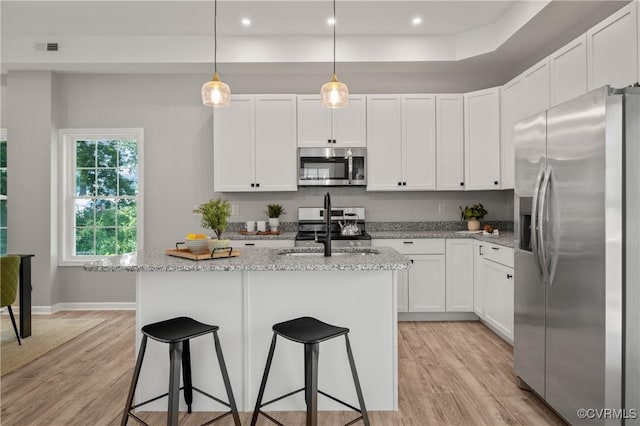 kitchen featuring white cabinetry, a sink, appliances with stainless steel finishes, and light wood-type flooring