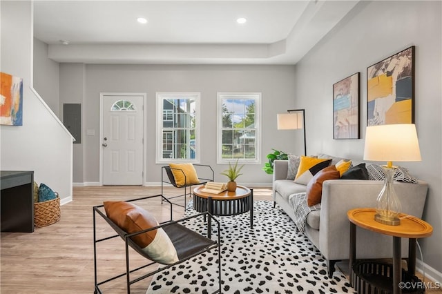 living area with baseboards, recessed lighting, electric panel, and light wood finished floors
