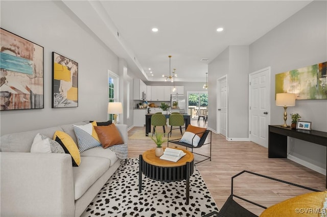 living room with light wood-style flooring, baseboards, and recessed lighting