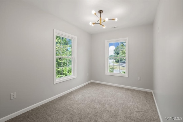 carpeted empty room featuring an inviting chandelier, baseboards, and visible vents