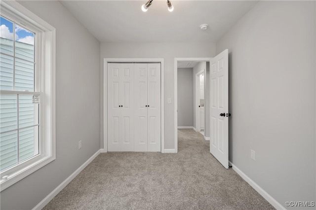 unfurnished bedroom with baseboards, a closet, and carpet