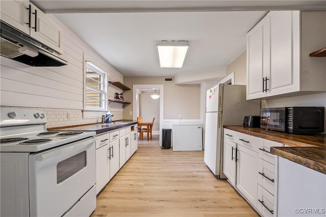 1016 Court St, Victoria, VA 23974 - kitchen with black microwave, open shelves, electric stove, and under cabinet range hood