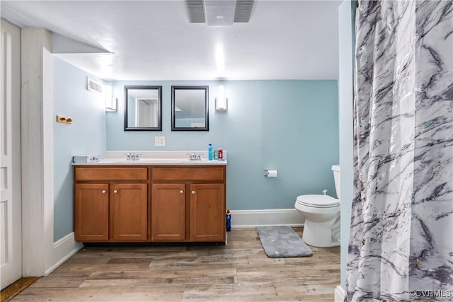1016 Court St, Victoria, VA 23974 - bathroom with toilet, wood finished floors, double vanity, and visible vents