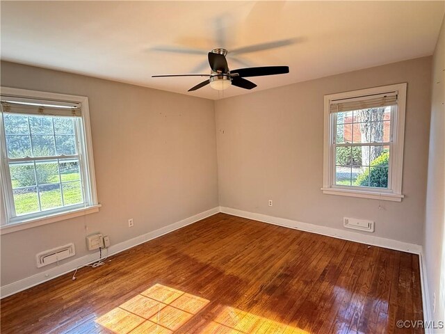 unfurnished room with plenty of natural light, ceiling fan, baseboards, and wood finished floors