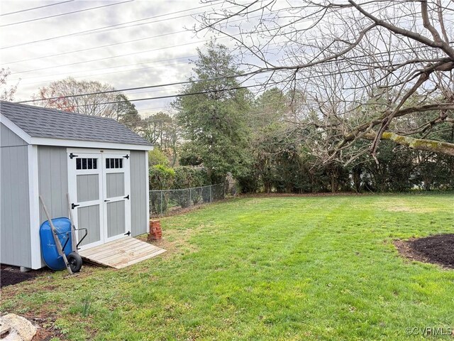 view of yard featuring a storage unit, fence, and an outdoor structure