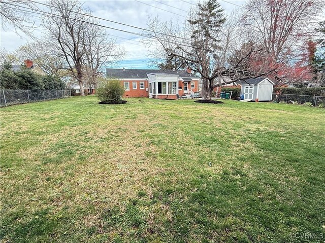 view of yard featuring an outbuilding, a fenced backyard, and a shed