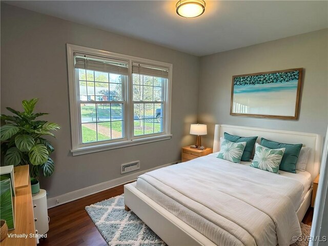 bedroom with baseboards, multiple windows, and dark wood finished floors