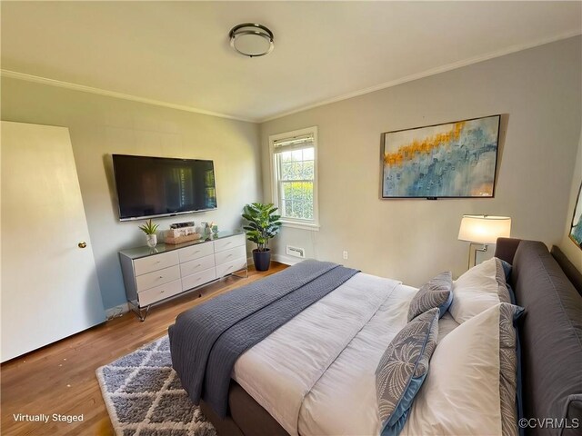bedroom featuring crown molding and wood finished floors