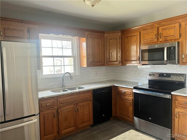 309 Royal Oak Ave, Colonial Heights, VA 23834 - kitchen featuring stainless steel appliances, brown cabinetry, backsplash, and dark tile patterned flooring