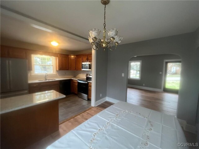 309 Royal Oak Ave, Colonial Heights, VA 23834 - kitchen featuring stainless steel appliances, arched walkways, light wood-type flooring, light countertops, and plenty of natural light