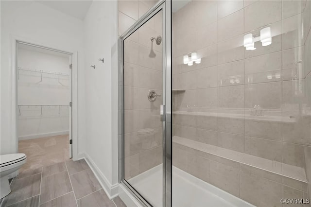122 Steyland St, Ashland, VA 23005 - bathroom featuring toilet, a shower stall, a walk in closet, and baseboards