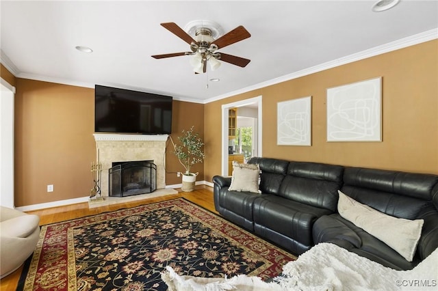 living room featuring ornamental molding, baseboards, wood finished floors, and ceiling fan