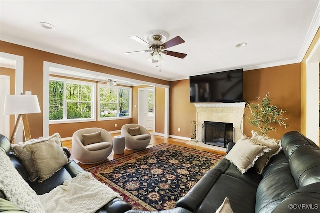 living room with ceiling fan, baseboards, crown molding, and wood finished floors