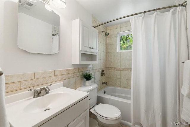 bathroom featuring toilet, tile walls, visible vents, shower / tub combo, and vanity