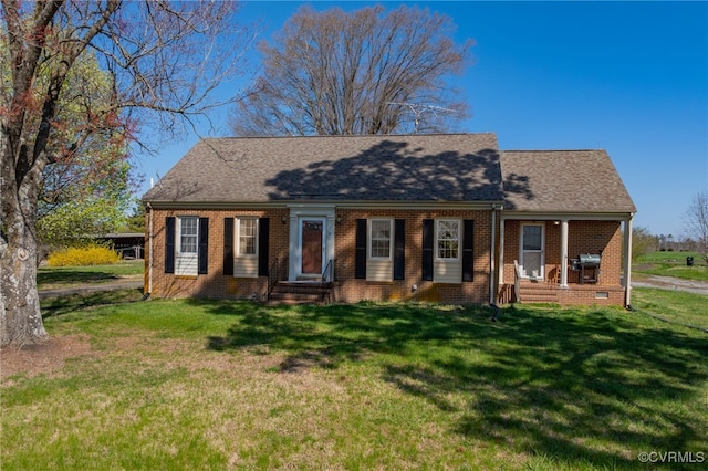 cape cod-style house with brick siding and a front yard