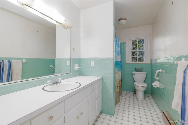full bathroom featuring toilet, vanity, a baseboard radiator, wainscoting, and tile walls