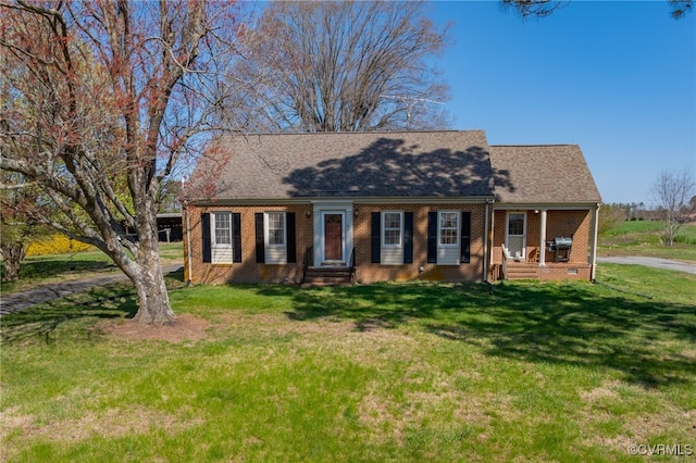 new england style home with brick siding, a front lawn, and roof with shingles