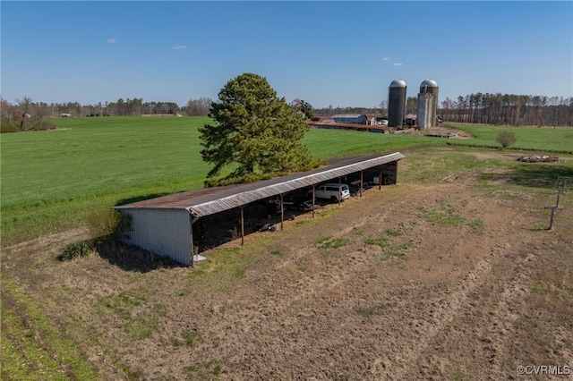 view of yard with an outbuilding, a pole building, a rural view, and a carport