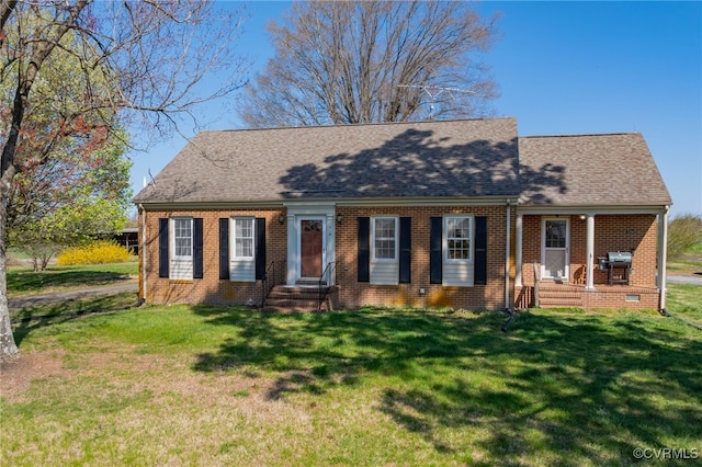 cape cod home featuring brick siding, a shingled roof, and a front lawn