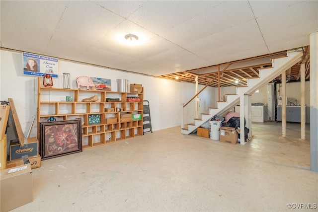 finished below grade area featuring concrete block wall, washer / dryer, and stairs