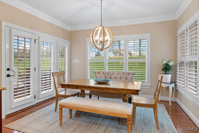 dining room featuring crown molding, wood finished floors, and a notable chandelier