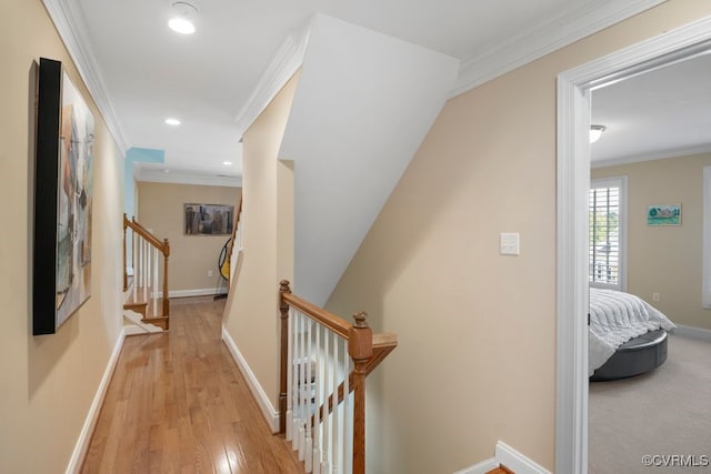 hallway with recessed lighting, light wood-type flooring, baseboards, and crown molding