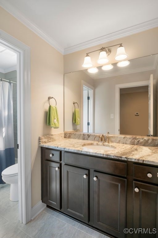 bathroom with ornamental molding, toilet, vanity, and tile patterned flooring