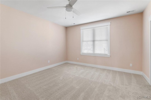 unfurnished room with baseboards, light colored carpet, and visible vents