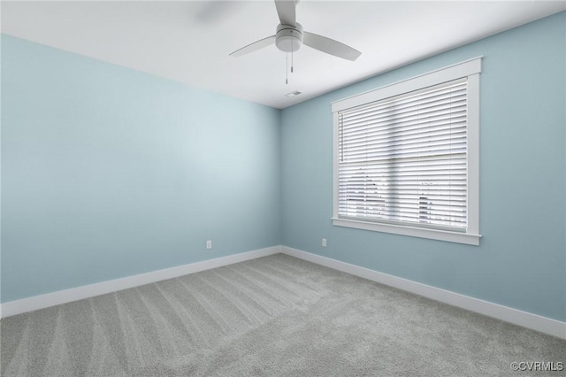 spare room with baseboards, visible vents, ceiling fan, and carpet flooring