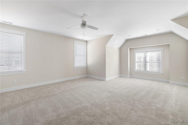 interior space with baseboards, lofted ceiling, ceiling fan, and visible vents