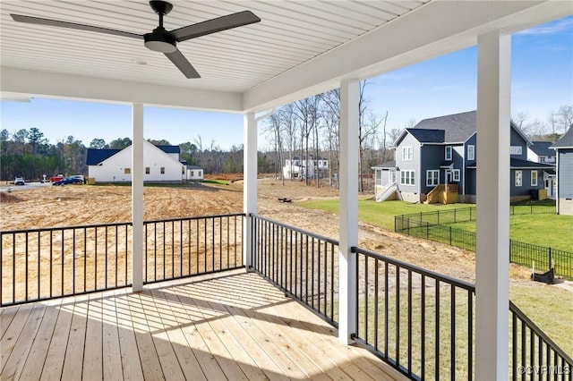 deck with a yard, fence, a ceiling fan, and a residential view