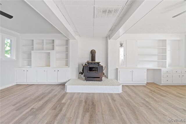 201 Winston Ave, Colonial Heights, VA 23834 - unfurnished living room with a wood stove, a ceiling fan, light wood-style flooring, and built in features