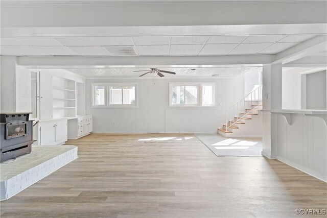201 Winston Ave, Colonial Heights, VA 23834 - unfurnished living room featuring a wood stove, a ceiling fan, healthy amount of natural light, and wood finished floors