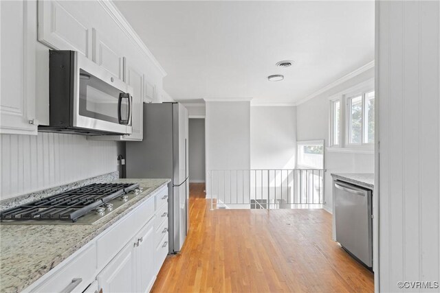 201 Winston Ave, Colonial Heights, VA 23834 - kitchen with appliances with stainless steel finishes, light wood-type flooring, white cabinets, ornamental molding, and light stone countertops