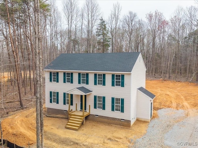 view of front of home with crawl space and roof with shingles