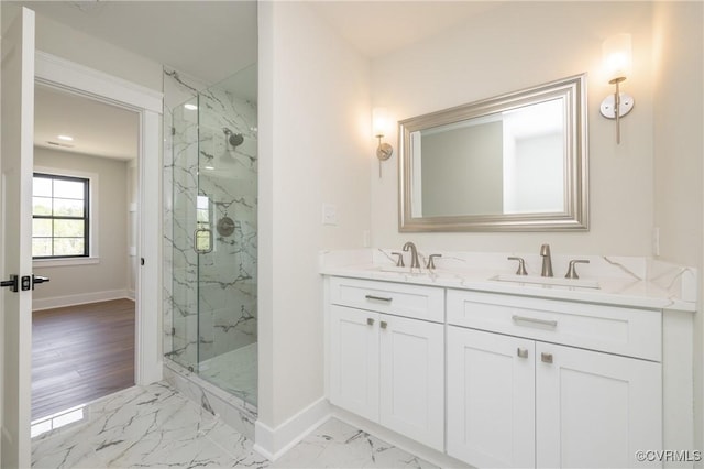 full bathroom featuring baseboards, marble finish floor, a sink, and a marble finish shower